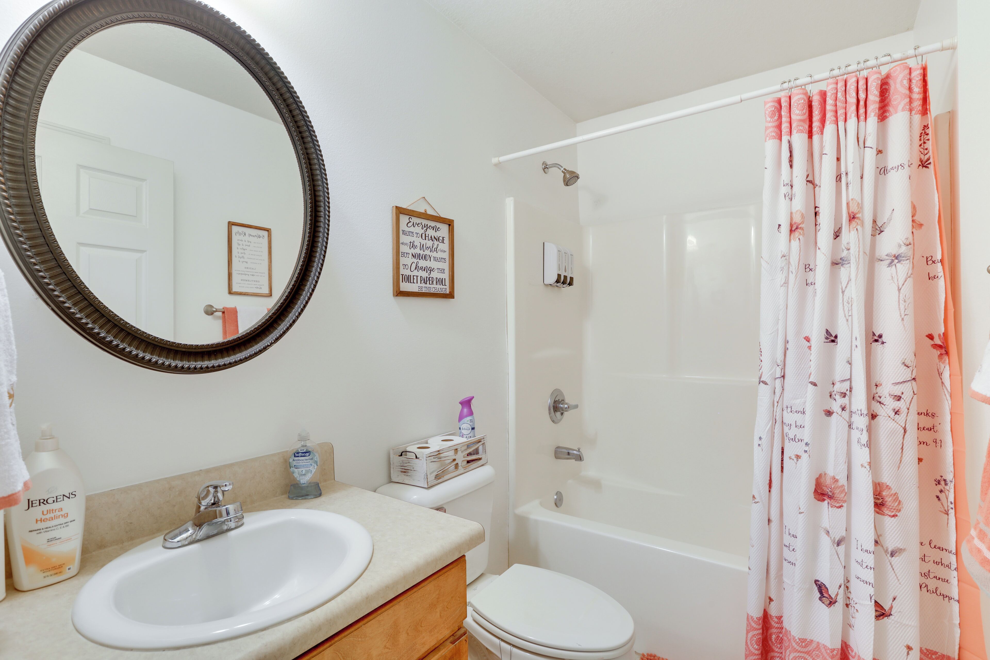 A bathroom with a sink, mirror, toilet, and shower.