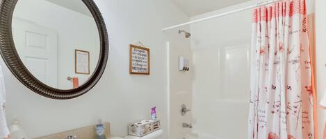 A bathroom with a sink, mirror, toilet, and shower.