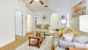 A living room with a ceiling fan, a clock, a sofa, a coffee table, and a painting on the wall. - Charming Abbeville Home w/ Private Boat Dock! (Abbeville)