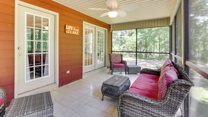 A covered patio with wicker furniture, a ceiling fan, and a sign that reads "Life is better at the lake." - Charming Abbeville Home w/ Private Boat Dock! (Abbeville)