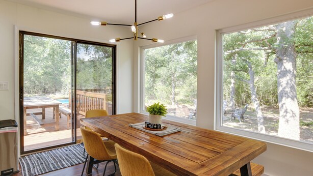 A dining area with a wooden table, two yellow chairs, and a potted plant. - Somerville Cabin w/ Private Pool! (Somerville)