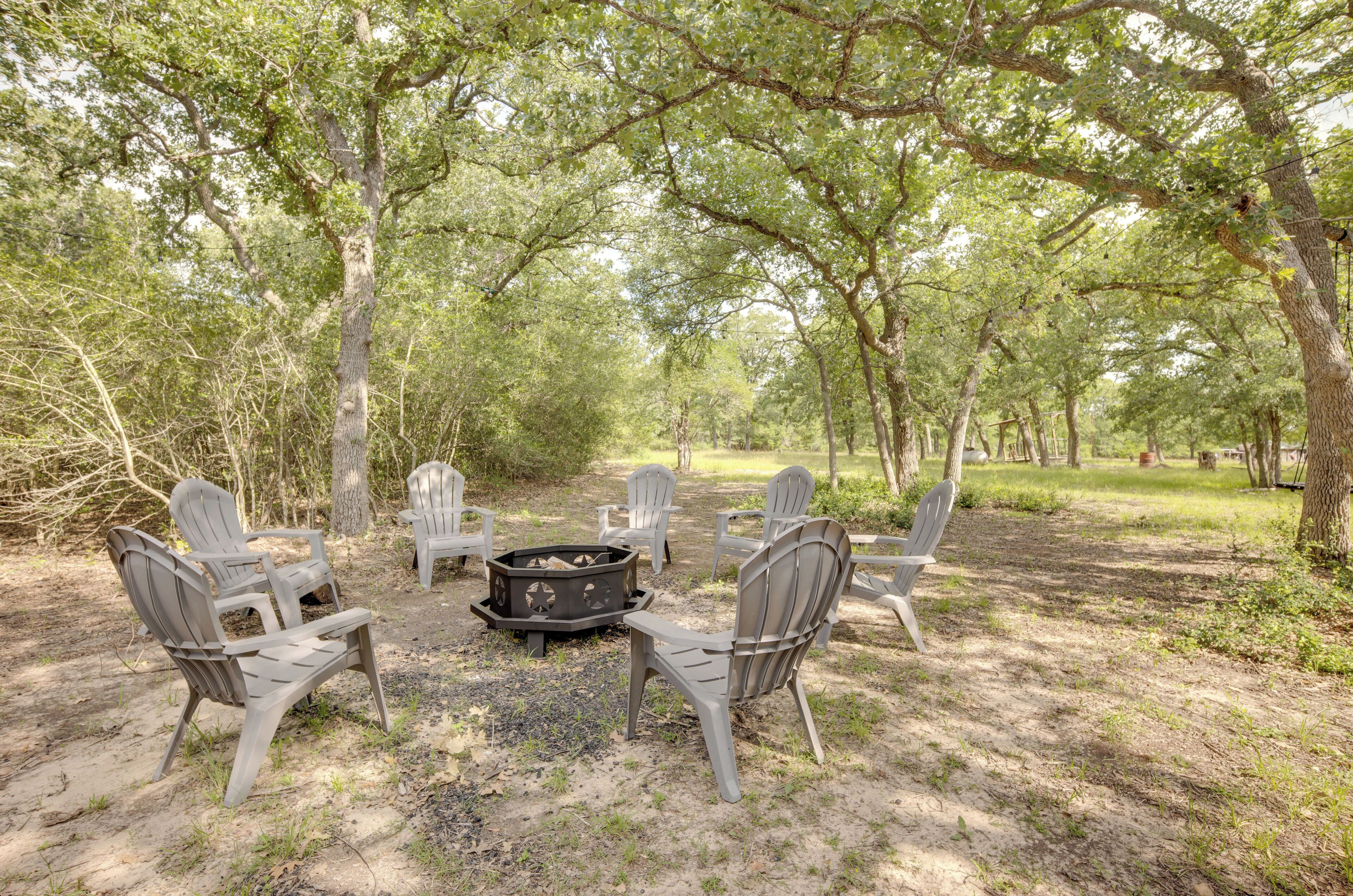 An outdoor seating area with Adirondack chairs arranged around a fire pit.