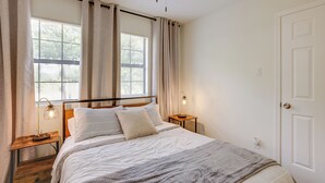 A bedroom with a bed, bedside tables, a ceiling fan, and a window with curtains. - Somerville Cabin w/ Private Pool! (Somerville)
