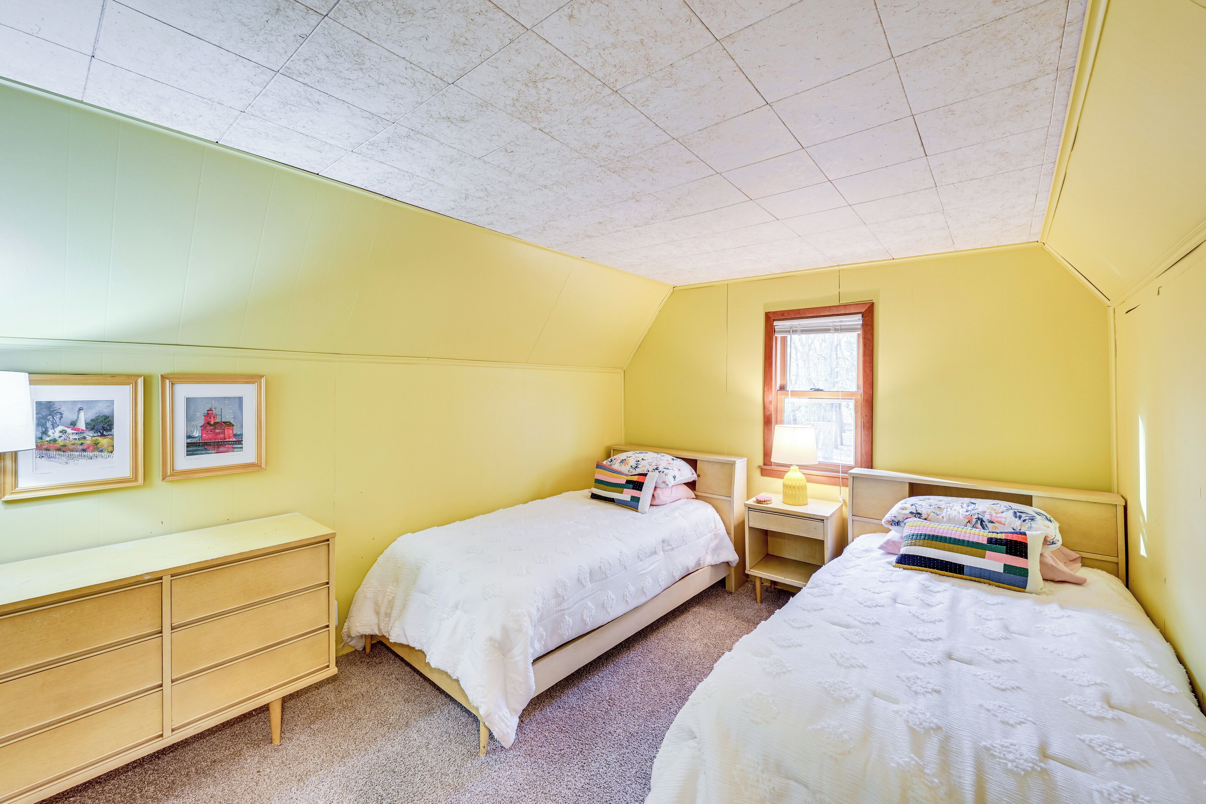 Une chambre avec deux lits, un bureau et une commode.