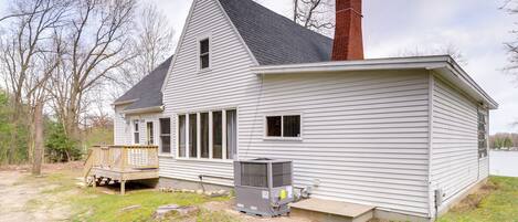 A single-story house with a gabled roof, a chimney, and a small deck.