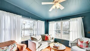 A living room with a blue ceiling, a ceiling fan, a sofa, a chair, and a coffee table. - Grand Junction Lake Home: 13 Mi to South Haven! (Grand Junction)