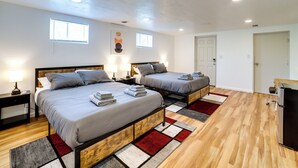 Un dormitorio moderno con dos camas, cabeceros de madera y un armario empotrado.