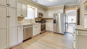 A spacious kitchen with light wood cabinets, stainless steel appliances, and a marble countertop. - Charming Bluffton Vacation Home w/ Yard! (Bluffton)