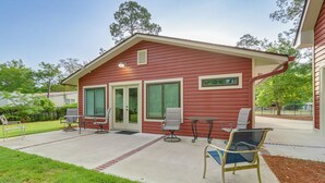 A red building with a patio area featuring outdoor furniture and a small table. - Charming Bluffton Vacation Home w/ Yard! (Bluffton)