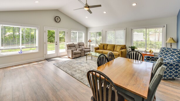 A spacious living area with a dining table, sofas, and a ceiling fan. - Charming Bluffton Vacation Home w/ Yard! (Bluffton)