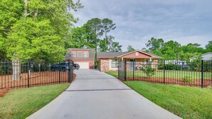 A suburban neighborhood with a paved driveway leading to a house with a garage. - Charming Bluffton Vacation Home w/ Yard! (Bluffton)