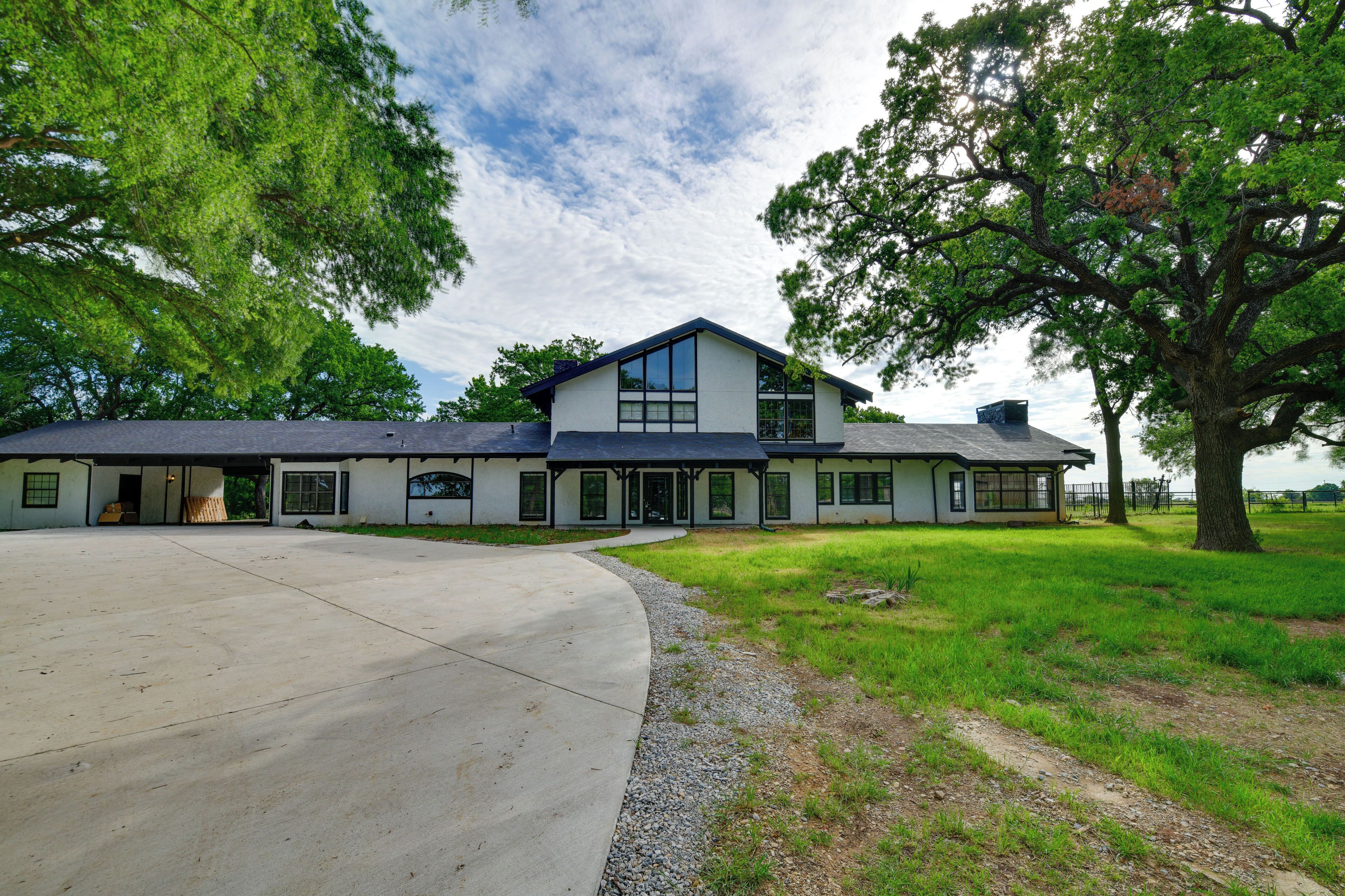 A large, single-story house with a spacious driveway and a well-maintained lawn.