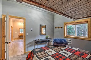 Relax in this serene bedroom with a large bed, wooden headboard, and a desk with a mirror.
