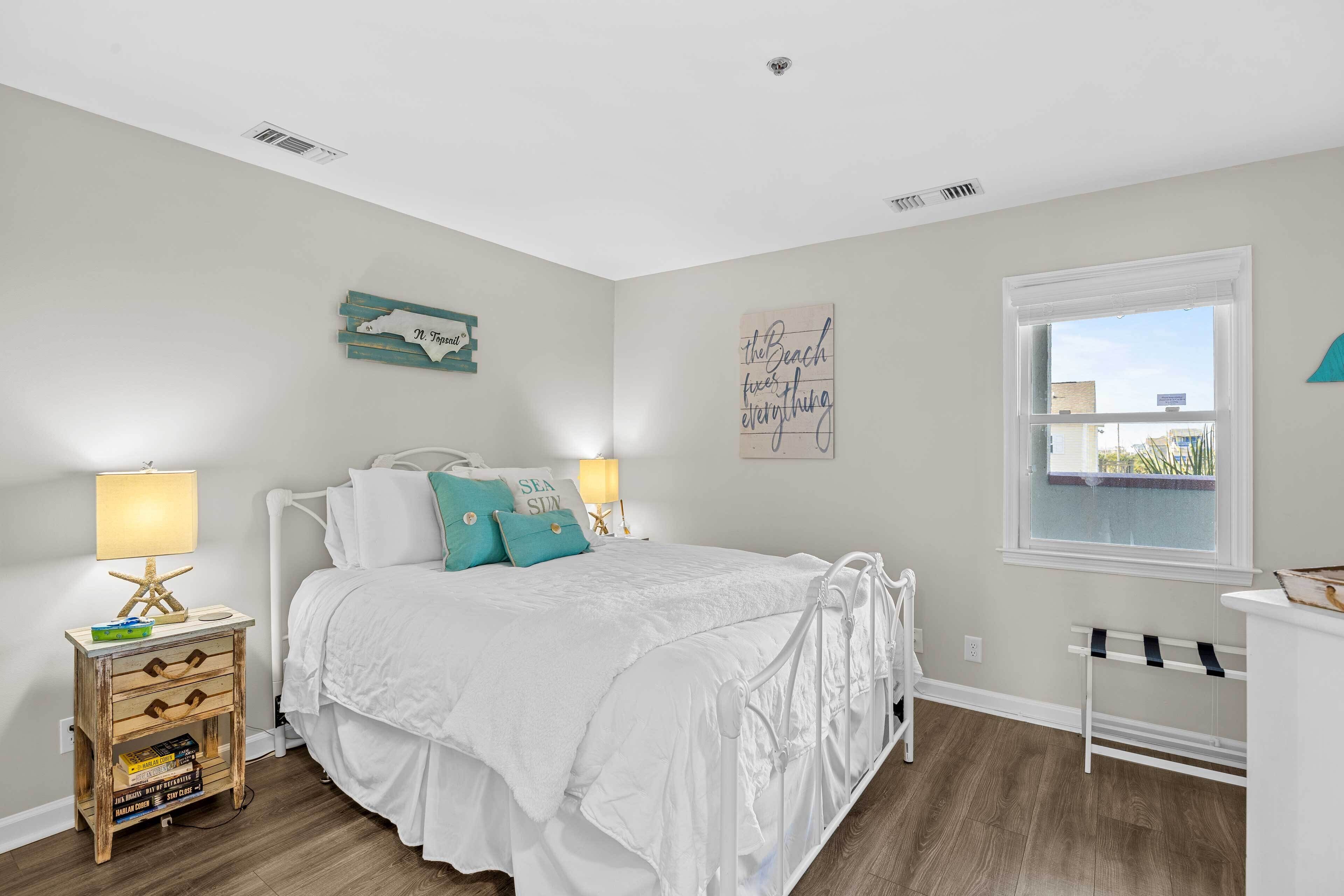 Une chambre à coucher avec un lit, des tables de chevet, une fenêtre et des éléments décoratifs sur les murs.