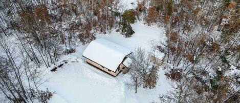 Una baita immersa nella neve, in una foresta.