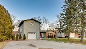 Ein zweistöckiges Haus mit Garage, Auffahrt und Rasen.