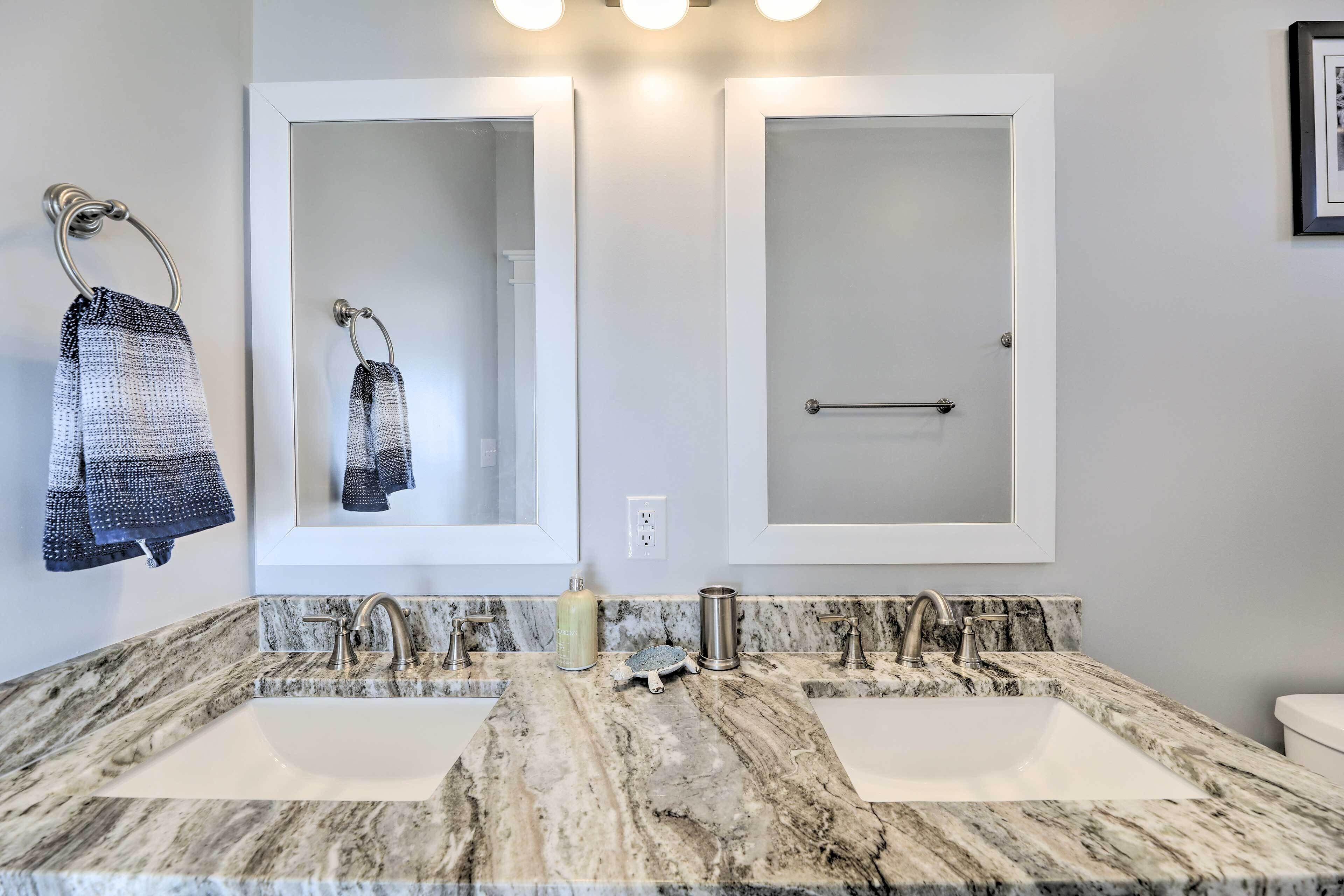 A bathroom with two sinks, a towel rack, and a mirror.