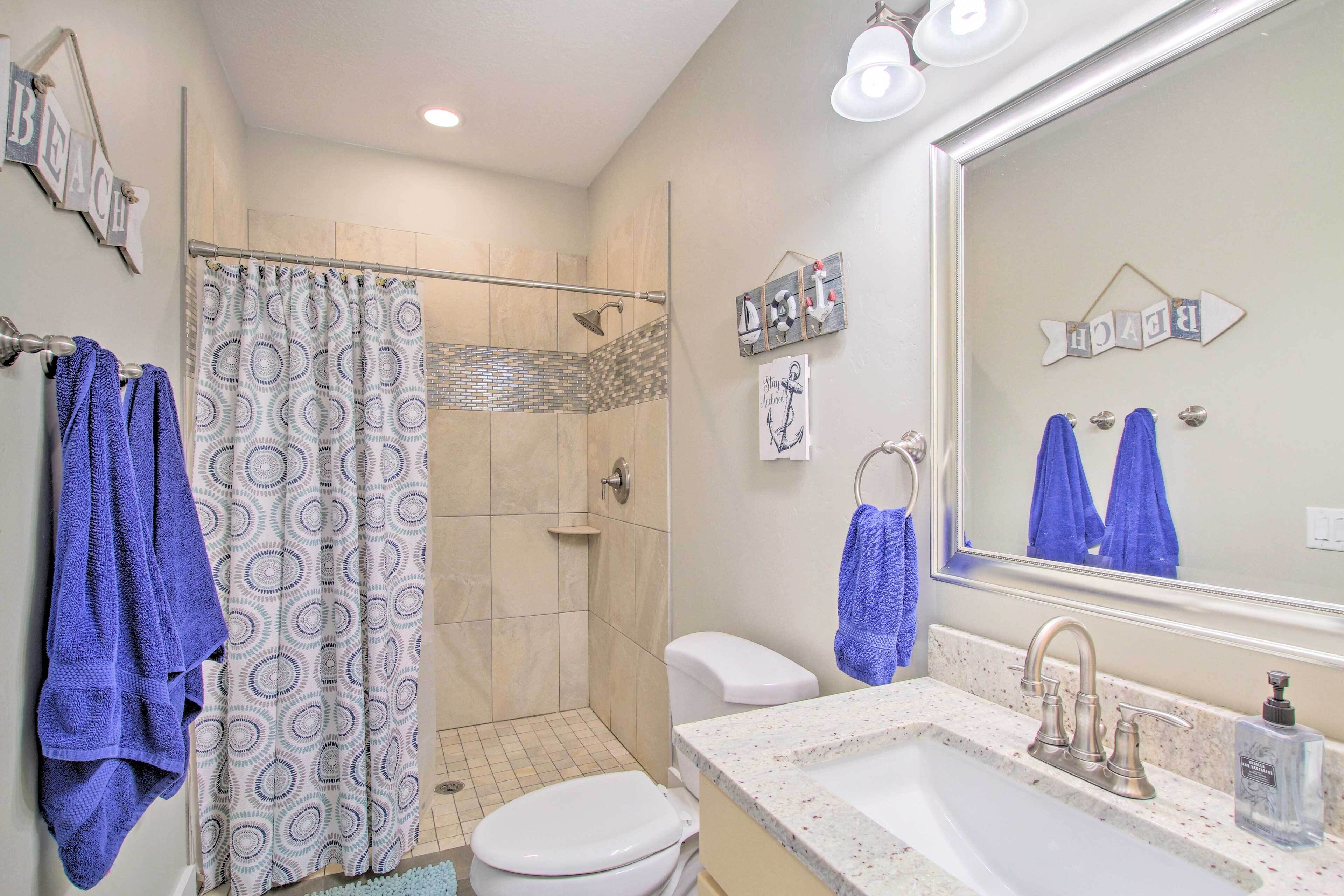 A bathroom with a shower, toilet, and sink.