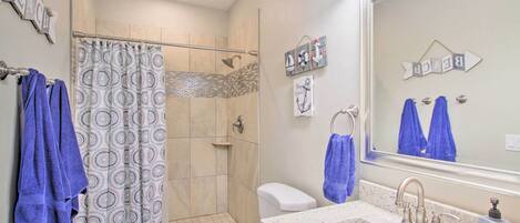 A bathroom with a shower, toilet, and sink.