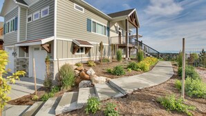 A two-story house with a covered porch, a stone foundation, and a landscaped front yard with a concrete pathway. - Garden City Gem: Private Hot Tub & Game Room! (Garden City)