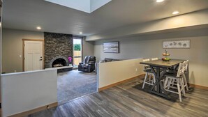 A spacious living area with a fireplace, a dining table with chairs, and a seating area with a couch. - Luxurious Tacoma Retreat w/ Quartz Countertops! (Puyallup)
