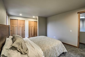 Ein Schlafzimmer mit einem Bett, zwei Holztüren und einem Teppichboden.
