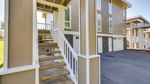A multi-story building with a covered outdoor staircase and a garage. - Luxurious Tacoma Retreat w/ Quartz Countertops! (Puyallup)
