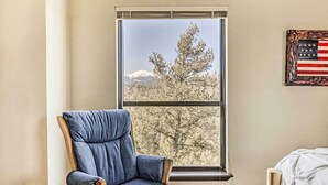 A room with a large window, a blue chair, and a bed. - Ruidoso 'memories Mountain Retreat' w/ Hot Tub! (Ruidoso)