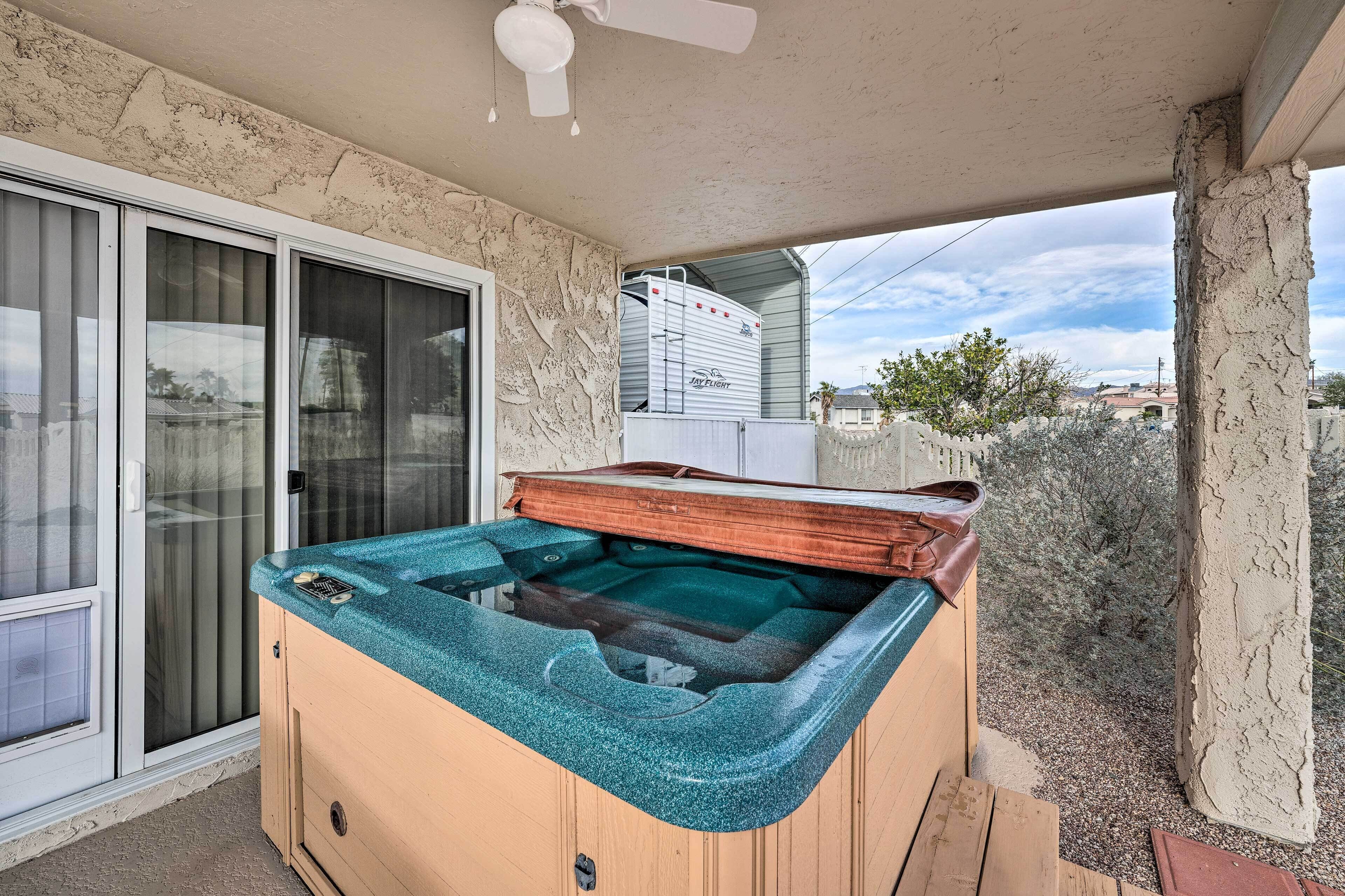 A hot tub with a wooden exterior and a view of a trailer in the background.