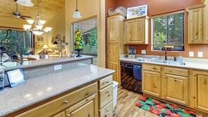 A kitchen with wooden cabinets, granite countertops, and a dishwasher. - Fireside Comfort & Family Fun: Wooded Show Low Gem (Show Low)