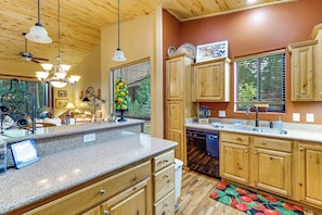 A kitchen with wooden cabinets, granite countertops, a dishwasher, and a window with blinds. - Fireside Comfort & Family Fun: Wooded Show Low Gem (Show Low)