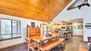 A spacious kitchen with wooden cabinets, a central island, and a dining area with a wooden table and benches.