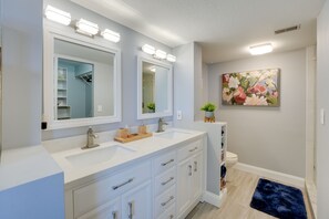 A bathroom with a double sink vanity, a large mirror, and a toilet. - Tranquil Redington Beach Condo w/ Beach Access (Redington Beach)