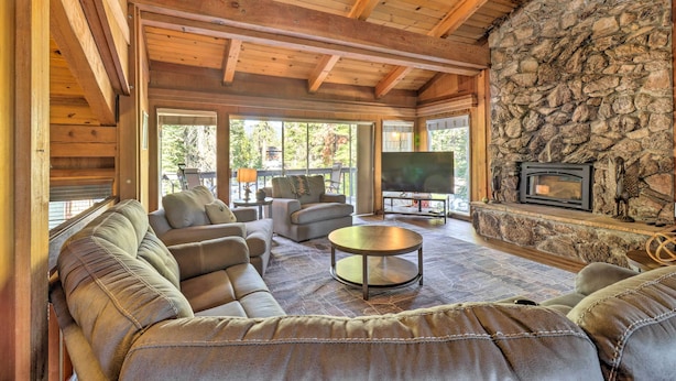 A spacious living room with a stone fireplace, leather sofas, and a large TV screen. - Ski & Soak: Hot Tub Haven in Tahoe City! (Tahoe City)