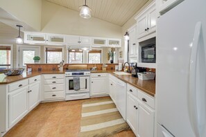 A kitchen with white cabinets, a stove, an oven, a refrigerator, and a microwave. - Lakefront Eufaula Vacation Rental w/ Private Dock (Eufaula)