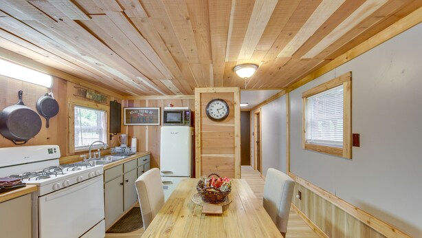 A wooden interior with a kitchen area, including a stove, microwave, and wooden cabinets. - Hemphill Home w/ Community Perks < 1 Mi to Water! (Hemphill)