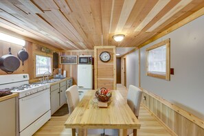 A wooden interior with a kitchen area, including a stove, microwave, and wooden cabinets. - Hemphill Home w/ Community Perks < 1 Mi to Water! (Hemphill)