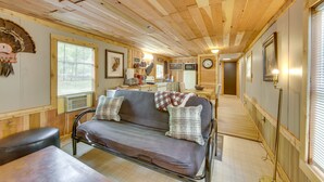 A cozy cabin interior with a sofa, a dining table, a kitchen area, and a hallway leading to another room. - Hemphill Home w/ Community Perks < 1 Mi to Water! (Hemphill)