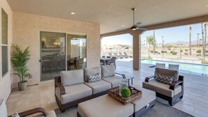 A spacious outdoor living area with a pool, comfortable seating, and a view of the pool area. - Luxury Spring Training Home Base in Goodyear! (Goodyear)