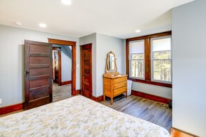 A bedroom with a large bed, wooden wardrobe, and a mirror. - Virginia Getaway - Deck, Grill & Mountain Views! (Whitetop)