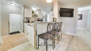 A modern kitchen with a central island, bar stools, and built-in appliances. - Cozy Lewiston Home - Near Lakes & Restaurants! (Lewiston)