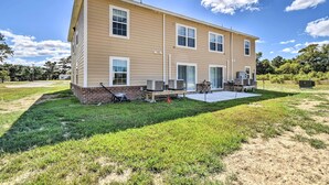 A two-story house with a patio, outdoor furniture, and a covered area. - Cozy Cape Charles Apartment: Walk to Beaches! (Cape Charles)