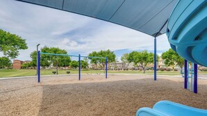A playground with a blue slide and swings under a shaded area. - Welcoming Phoenix Home w/ Community Amenities! (Phoenix)
