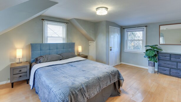 A bedroom with a large bed, a nightstand, a dresser, and a potted plant. - ~ 20 Mi to Manhattan: Quaint Clifton Home! (Clifton)