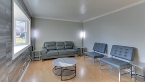 A modern living room with a grey sofa, two armchairs, a round coffee table, and a small side table. - ~ 20 Mi to Manhattan: Quaint Clifton Home! (Clifton)