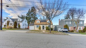 A residential street with houses, a clear sky, and a car parked on the side. - ~ 20 Mi to Manhattan: Quaint Clifton Home! (Clifton)