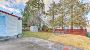 A backyard with a stone pathway, a swing set, and a shed. - ~ 20 Mi to Manhattan: Quaint Clifton Home! (Clifton)