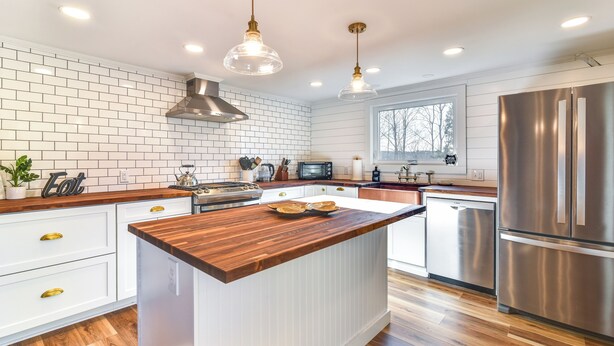 A modern kitchen with white cabinetry, a wooden island, stainless steel appliances, and pendant lighting. - Quiet Waterfront Home: Ideal Maine Escape! (Bass Harbor)