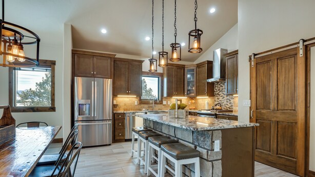 A modern kitchen with a central island, stainless steel appliances, and wooden cabinetry. - ~ 3 Mi to Granby Ranch: Spacious Cabin Home! (Granby)