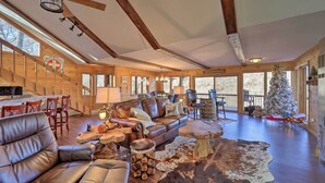 L’intérieur chaleureux d’un chalet en bois, avec un canapé en cuir, une table à manger en bois et un sapin de Noël.